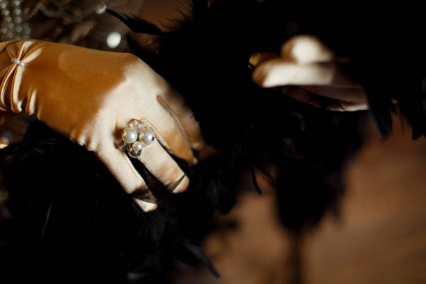 ring decorated with white pearls on a hand in a beige satin glove