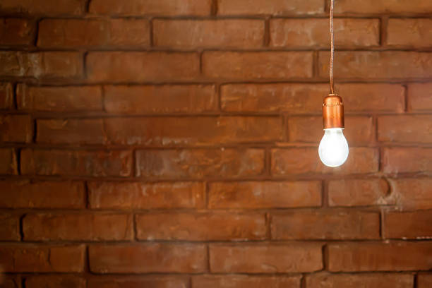 burning lamps with wires on a background of a red brick wall, as an idea, thought