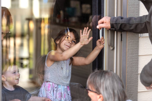 istock Grandparents visiting grandkids during quarantine through window 1222808014