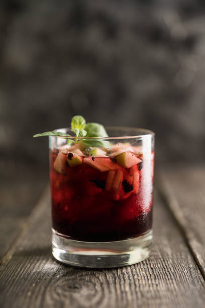 istock Old fashioned cocktail with blackberry liqueur and apple slices on rustic background 1222808250