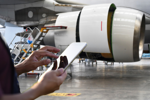 Male engineer using digital tablet for airplane mechanics