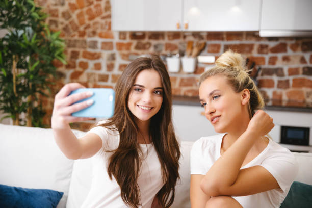 istock Two young girls using phone at home. 1222810401
