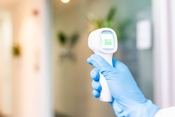 istock One hand holding a thermometer while measuring body temperature 1222811855