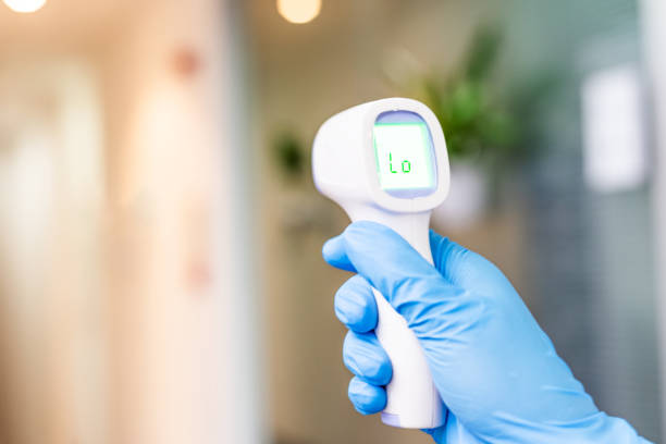 istock One hand holding a thermometer while measuring body temperature 1222811883