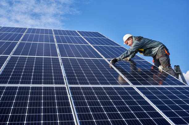 istock Male worker on solar plant installing solar batteries, standing on a ladder on a sunny day 1222813457