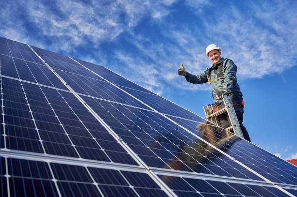 istock Male worker on solar plant installing solar batteries, standing on a ladder on a sunny day 1222813492