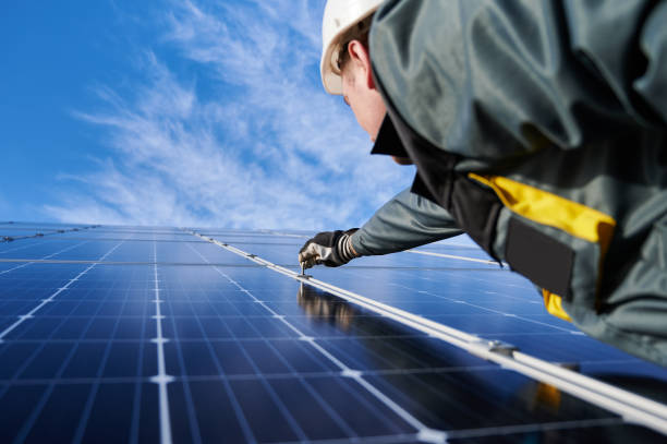 istock Workman standing on the ground trying to fasten solar batteries together, installing process 1222813495
