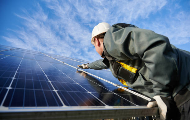 istock Workman standing on the ground trying to fasten solar batteries together, installing process 1222813510