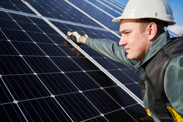 istock Workman standing on the ground trying to fasten solar batteries together, installing process 1222813561
