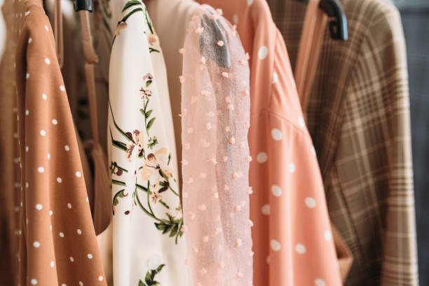 kapsel kleidung in beige und rosa farben nahaufnahme - clothing closet hanger dress stock-fotos und bilder