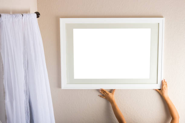 istock Straightening a blank white picture frame on a beige wall. 1222818968