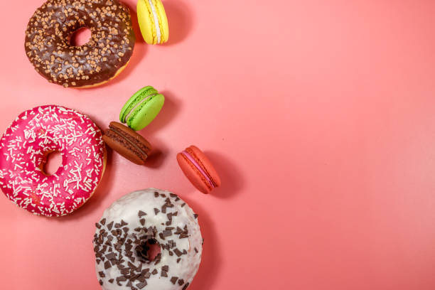 istock Tasty donuts and macaroons on pink background. Top view, copy space 1222820213