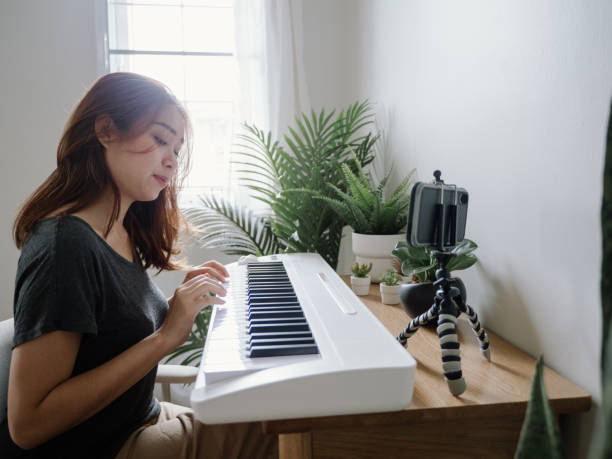 istock Young Woman Giving Piano lesson On Internet With Video Tutorial At Home. 1222822949