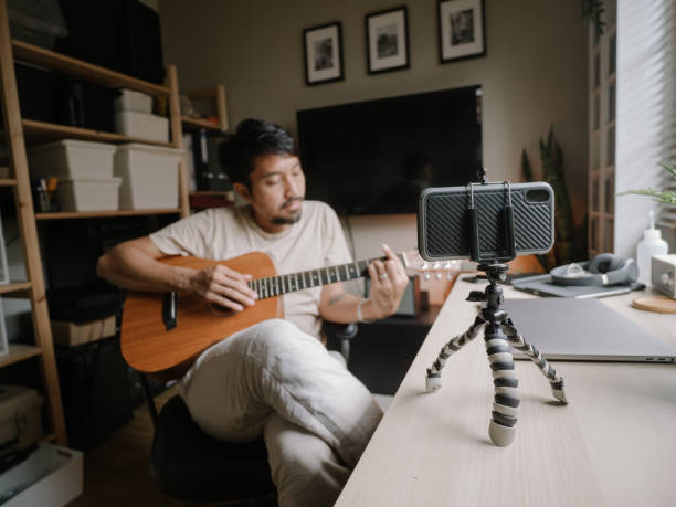 istock Home Alone guitar Hobby Mature man Practicing Guitar With Smartphone 1222823005