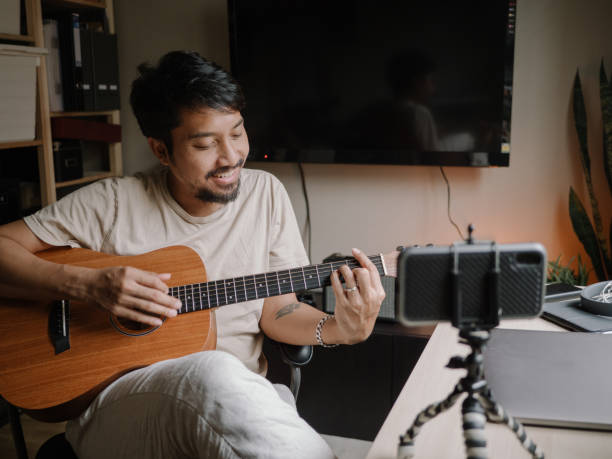 istock Home Alone guitar Hobby Mature man Practicing Guitar With Smartphone 1222823177