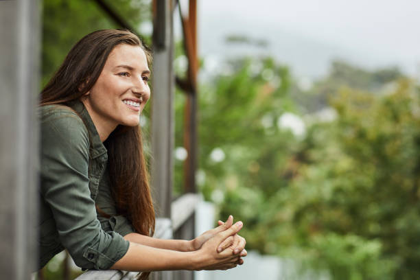 Smiling woman at window during corona lockdown