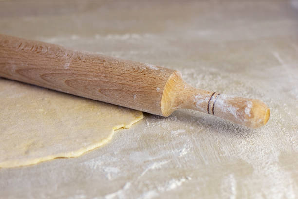 istock Rolling pin with dough on wooden worktop. Rolled out pizza dough. 1222825348