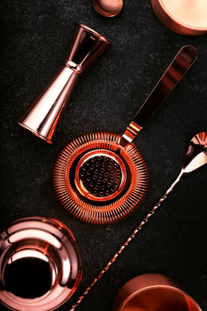istock Copper bar tools and accessories for making cocktail. Shaker, jigger, strainer, spoon, tongs, muddler. Alcohol drink and beverages preparation concept. Black background, top view, copy space 1222829709