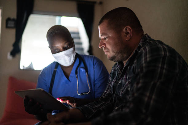 istock Health visitor and a mid adult man during home visit - using digital tablet 1222831568