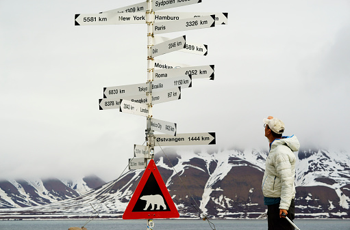 Polar bear warning sign, a male traveler has just traveled to Longyearbyen