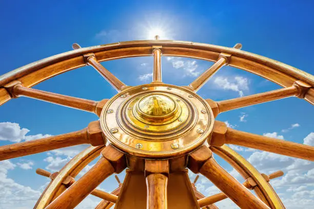 close up of an steering wheel against a sunny sky