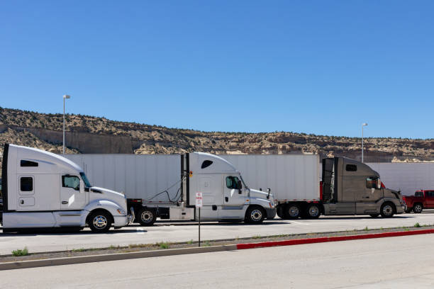 istock Three big rigs semi trucks of different brands models are lined up in parking 1222839207