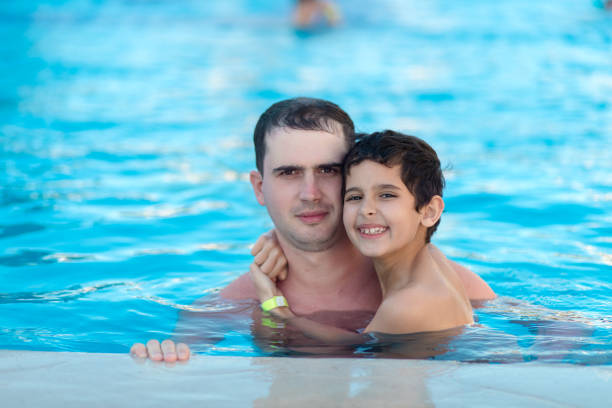 istock Man and boy are in the swimming pool 1222842813