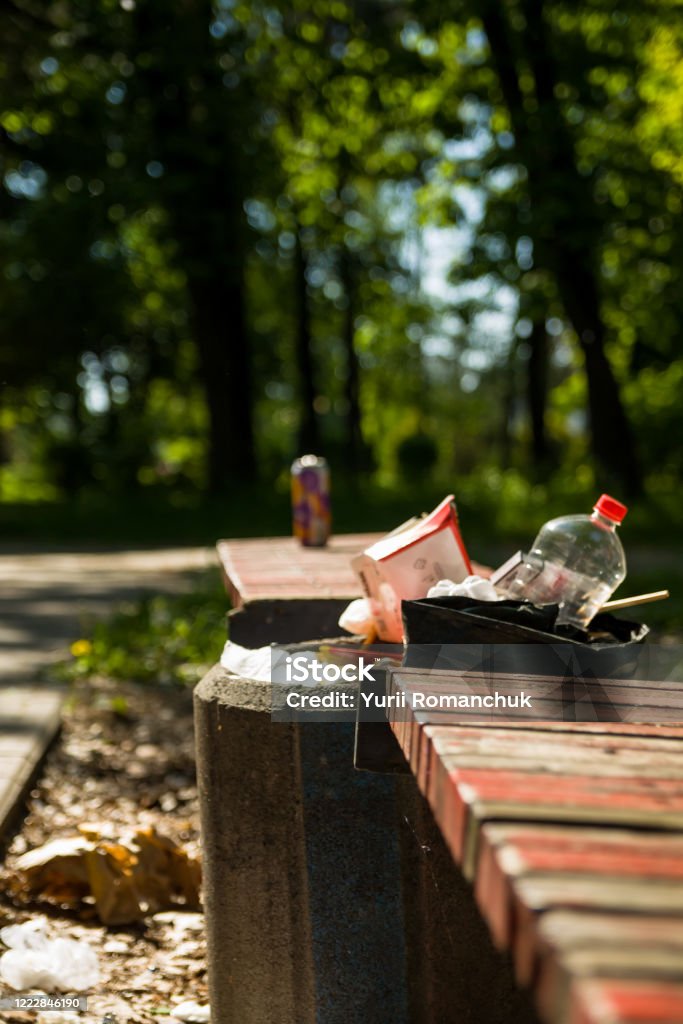 Garbage bins at the benches in the city park. scattered trash Adventure Stock Photo