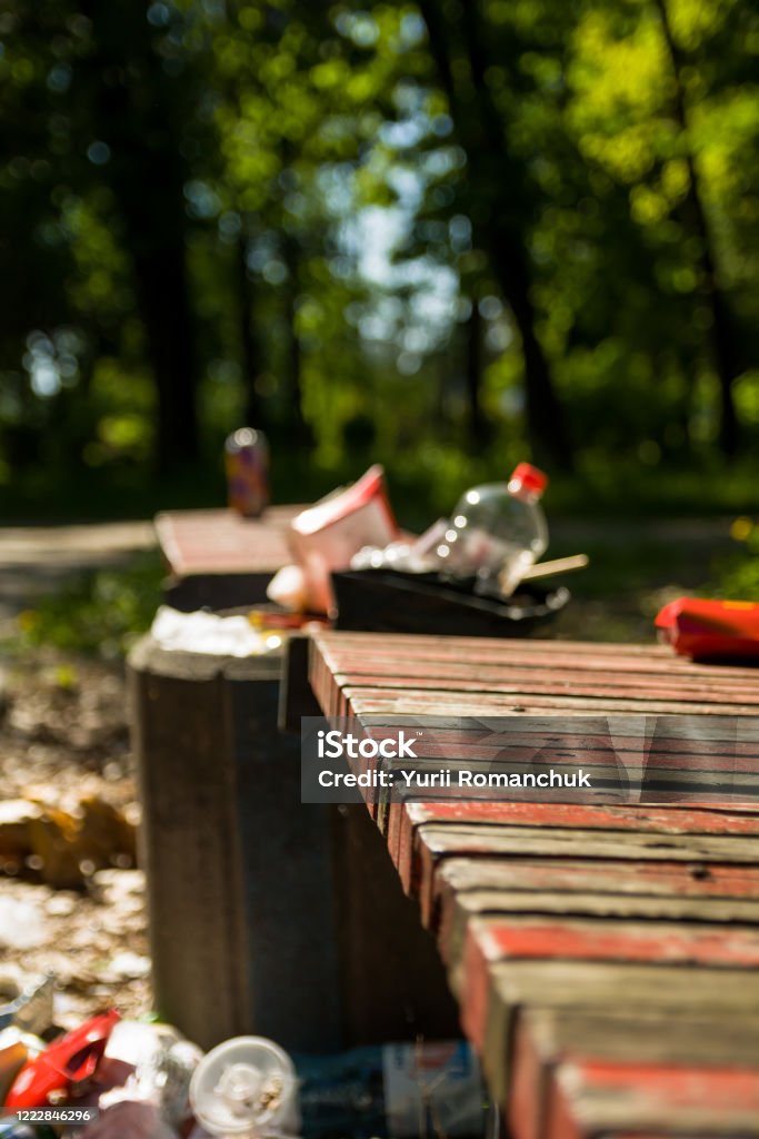 Garbage bins at the benches in the city park. scattered trash Garbage Stock Photo