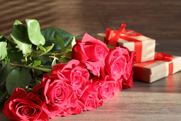 istock Bouquet of red  roses and present boxes on a dark background 1222847121