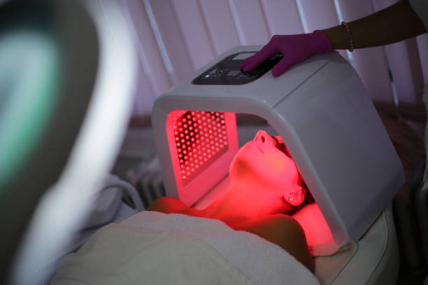 Young woman on light therapy in beauty salon. Omega Light Therapy A young woman is having phototherapy in a beauty salon. Omega Light Therapy light therapy stock pictures, royalty-free photos & images