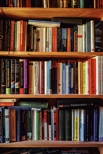 Section of a library with advanced physics and mathematics textbooks.