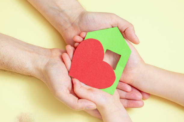 istock Hands holds green paper house with red heart. 1222852494