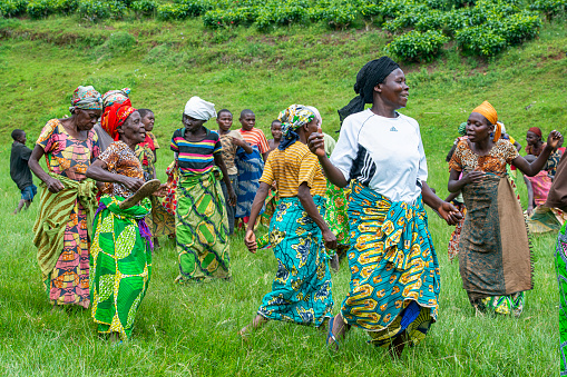 Buyungule Village, South-Kivu, Congo, Democratic Republic - January 03, 2016: A group of pygmy women is dancing in their village Buyungule, they are celebrating the arrival of some foreign visitors. Some of the women are carrying their children on the back while they are dancing. The dance takes place on the main place of the village. Buyungule is a village of the Batwa Pygmies, the native people of the Kahuzi Biega area.\nKahuzi-Biega Forest was the home of Batwa pygmies before it  was gazeeted as a National Park in 1970.  The life of the pygmy people was closely linked to the forest – there they found all what they needed for their life (food, medicine, shelter, etc.).  After the loss of their original habitat a lot of Pygmy people feel that they have lost their dignity as human being.