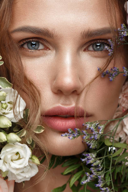 hermosa mujer con maquillaje clásico desnudo, peinado ligero y flores. cara de belleza. - women spring sensuality fashion model fotografías e imágenes de stock