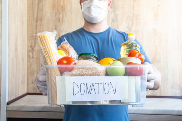 человек держит пожертвование окно, полное пищи - food canned food drive motivation стоковые фото и изображения