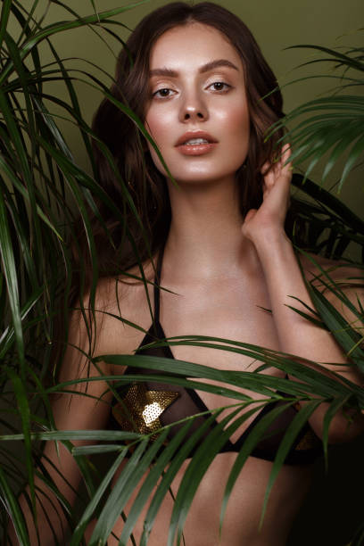 istock woman in bikini, green plants. 1222856525