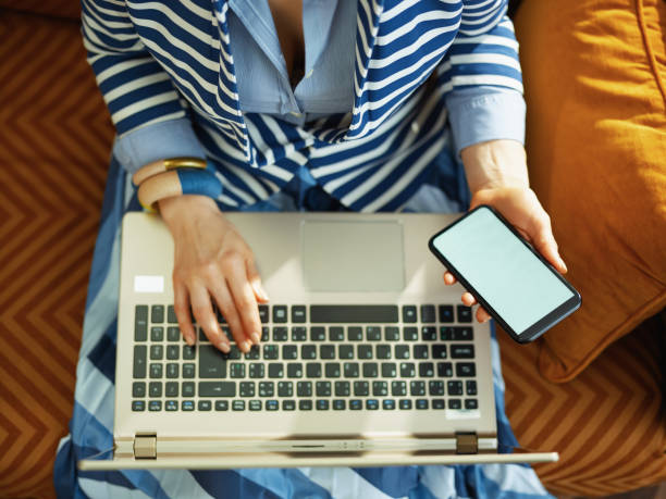 istock female using laptop and smartphone with blank screen 1222856714