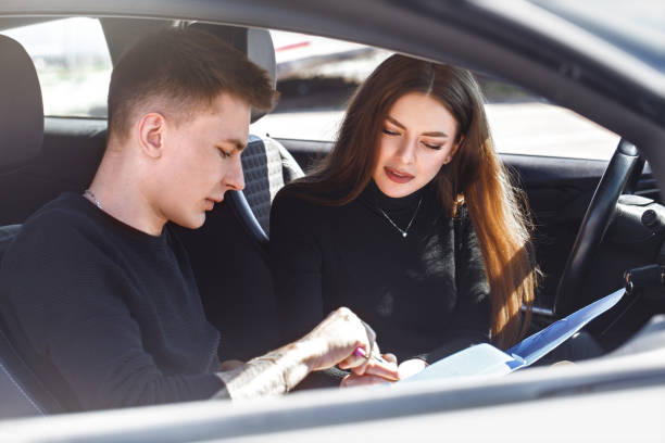 istock Driving instructor and woman student in examination car. 1222858085