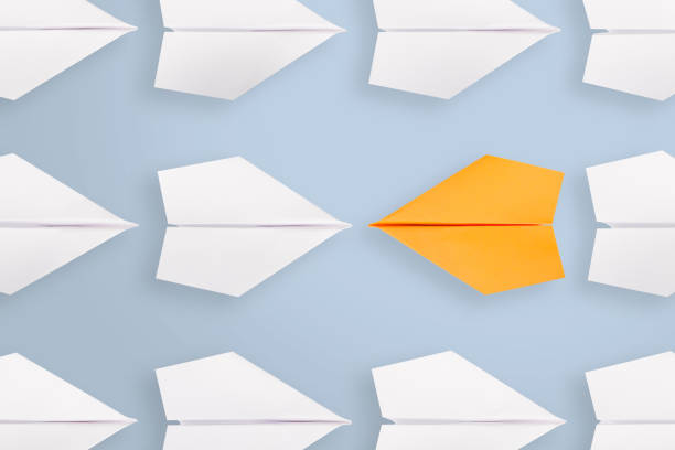 istock Change concepts with orange paper airplane leading among white 1222858239