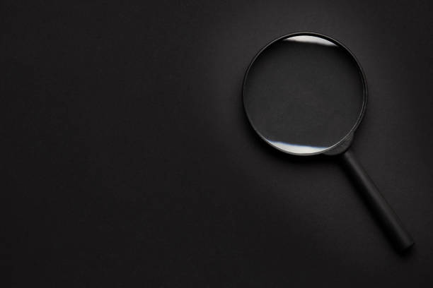 istock search concept. black on black. magnifier on dark background. view from above. copy space for design. 1222860006
