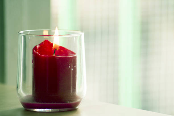 istock Burning red candle inside a clear glass vase. No people 1222860248