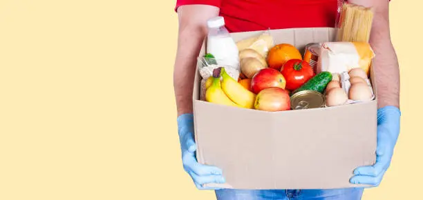 Photo of Food box in male hands in medical gloves