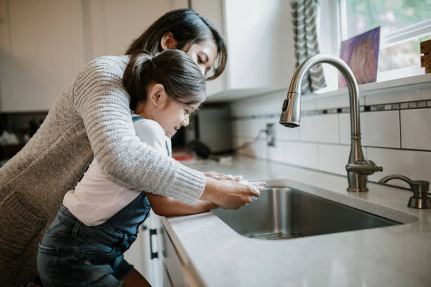 istock Mother Helps Daughter Wash Hands With Good Technique 1222861322