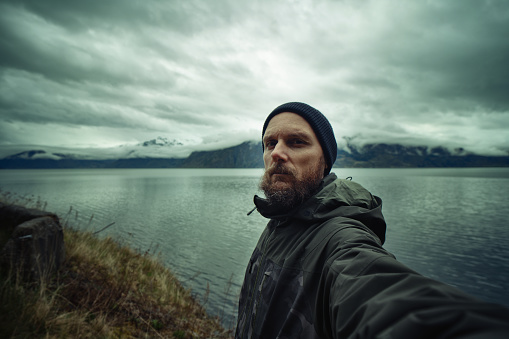 Man selfie video by a placid sea of a fjord, Sognefjord in Norway