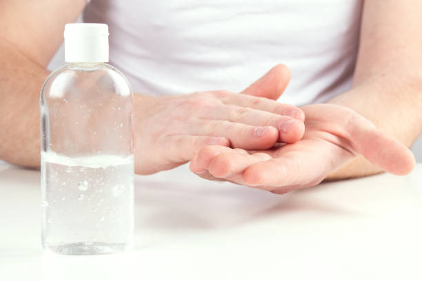 istock Man person using small portable antibacterial hand sanitizer on hands. 1222871347