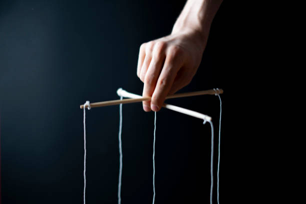 istock controling your mind, twisted sticks with ropes in the hand, puppet concept, isolated 1222872512