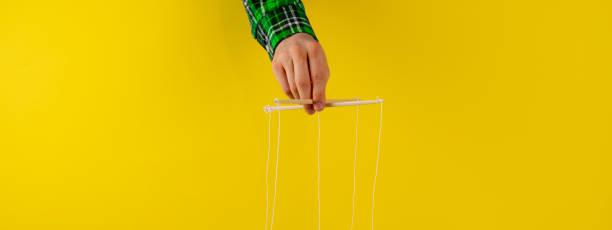 istock controling your mind, twisted sticks with ropes in the hand, puppet concept, isolated wide web banner 1222872537
