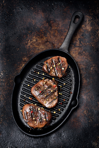 Barbecue grilled beef medallions in a cast iron griddle