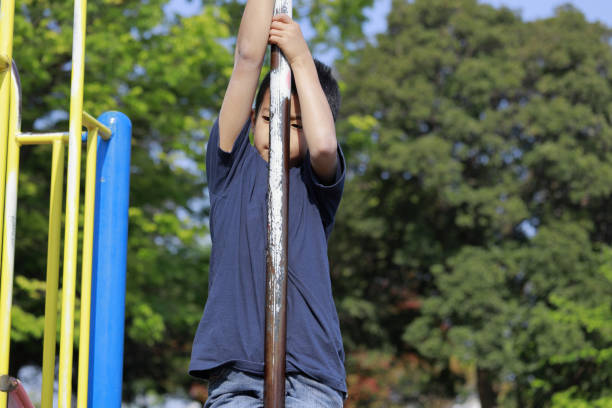 istock Japanese boy playing with climbing pole (fifth grade at elementary school) 1222876524